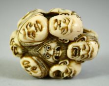 A JAPANESE CARVED IVORY NETSUKE, carved as a roundel of noh masks, 5.5cm.