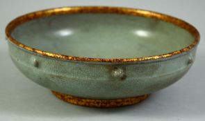 A CHINESE CELADON AND GILT RIM PORCELAIN BOWL, the exterior with seven raised bosses, the base