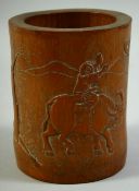 A CHINESE CARVED BAMBOO BRUSH POT, the side carved with a figure on an oxen, 15cm high.
