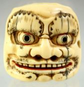 A JAPANESE CARVED IVORY DOUBLE SIDED NOH MASK NETSUKE, signed to the base, 4cm wide.