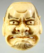 A JAPANESE CARVED IVORY NOH MASK NETSUKE, signed to the reverse, 4cm.