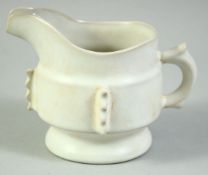 A SMALL CHINESE IVORY GLAZE PORCELAIN JUG, the base with four character mark, 12cm wide (handle to