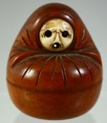 A JAPANESE CARVED BOXWOOD AND IVORY KOBE TOY, modelled as a seated figure, 5cm high.