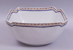 A CHINESE / EUROPEAN SQUARE FORM PORCELAIN BOWL, with red, blue and gilt work rim, 25.5cm diameter.