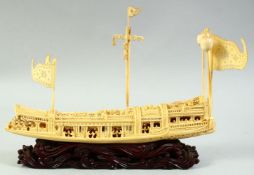 A FINE CHINESE CARVED IVORY BOAT on a hardwood stand, the boat carved with many figures aboard,