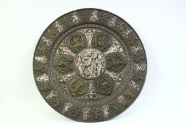 A LARGE INDIAN SILVER ONLAID COPPER CHARGER, with raised panels of various figures including