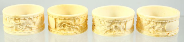 A SET OF FOUR CHINESE CARVED IVORY NAPKIN RINGS, each carved with a dragon, 4cm diameter.