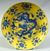 A CHINESE BLUE, WHITE AND YELLOW PORCELAIN DRAGON DISH, further decorated with floral motifs, six