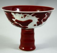 A CHINESE IRON RED GROUND PORECLAIN STEM CUP, the exterior with incised white dragon, bowl 14.5cm