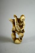 A JAPANESE CARVED IVORY NETSUKE of a sage holding a scroll seated on a rearing horse, signed to
