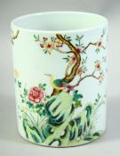 AN EARLY 20TH CENTURY CHINESE FAMILLE ROSE PORCELAIN BRUSH POT, painted with birds and native flora,