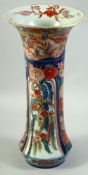 A LARGE JAPANESE IMARI PORCELAIN SLEEVE VASE, painted with a village landscape with panels of