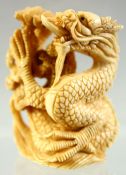 A JAPANESE CARVED IVORY NETSUKE OF A DRAGON, signed to base, 4.5cm high.