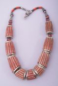 A NEPALI CORAL AND WHITE METAL NECKLACE.