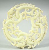 A LARGE CARVED AND PIERCED NEPHRITE JADE / HARDSTONE DRAGON DISK, 14cm diameter.