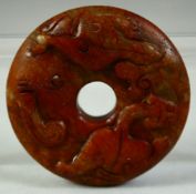 A SMALL CHINESE CARVED HARDSTONE DISK, carved with chilong motif, 6cm diameter.