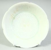A CHINESE CELADON PETAL SHAPE DISH, with carved floral pattern to the centre, 15.5cm diameter.