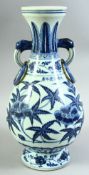 A CHINESE BLUE AND WHITE TWIN HANDLE PORCELAIN VASE, the body painted with native flora, the two