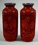 A PAIR OF CHINESE CINNABAR LACQUER VASES, with panels of native flora, the base and interior