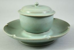 A CHINESE RU STYLE CELADON TEACUP, COVER AND SAUCER, saucer diameter 18.5cm.