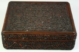 A GOOD INDIAN CARVED WOOD LIDDED RECTANGULAR BOX, the exterior carved all over with foliate