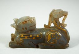 A CHINESE CARVED HARDSTONE FIGURE of a reclining beast, with painted gilt highlights, 7cm long.