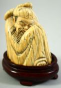 A CHINESE CARVED MAMMOTH IVORY FIGURE of a crouching sage, on a fitted hardwood base, figure 7.5cm