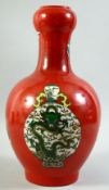 A LARGE CHINESE RED GROUND PORCELAIN VASE, painted with different vases and a large jar and cover;