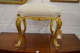A carved giltwood and upholstered stool.