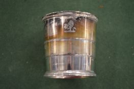 A collapsible silver drinking cup.