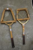 Two old tennis racquets with presses.