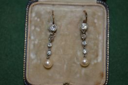A pair of diamond and pearl drop earrings.