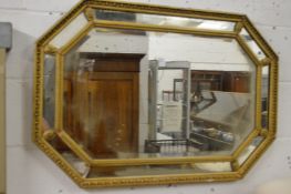 A gilt framed mirror of octagonal outline.