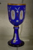 A Bohemian gilt decorated blue glass goblet.