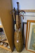 A wicker basket containing walking sticks and parasols.