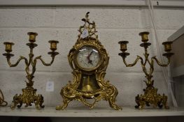 An ornate gilt metal three piece clock garniture.