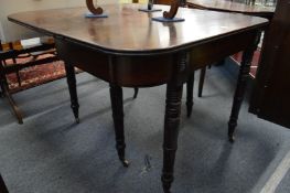 A Regency mahogany extending dining table with two leaves, with ratchet style mechanism, on turned