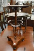 An unusual mahogany circular table with column support, basket below on a concave sided base.
