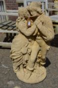 A weathered composite garden ornament modelled as young lovers.