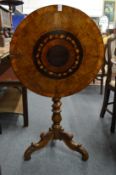 A 19th century walnut and inlaid circular tilt top occasional table on carved tripod base.