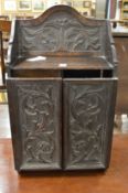 A small carved oak two door wall cabinet.