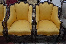 A pair of Edwardian inlaid mahogany framed armchairs with shaped backs on cabriole legs, upholstered