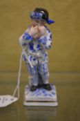 A small porcelain figure of a boy.