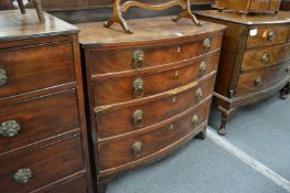 A George III mahogany bow front chest of four long drawers with lion's mask and ring brass handles.