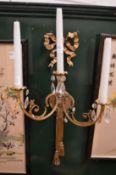 An ormolu and cut glass three light wall sconce.