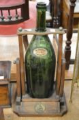 A large Remy Martin champagne cognac bottle in its original wooden pouring stand.