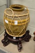 A large eastern pottery vase on stand.