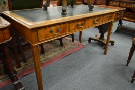 A yew wood three drawer writing table.
