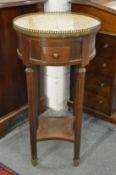 A continental circular marble topped drum table, the fluted legs united by an under tier.