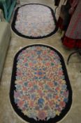 A floral decorated rug and matching larger rug.